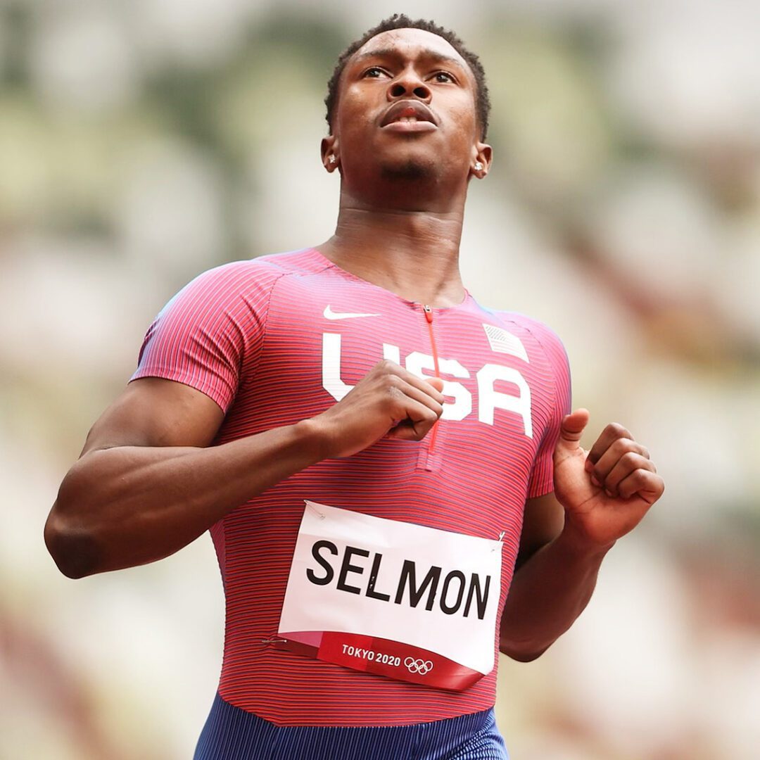 A man in red shirt running on track.