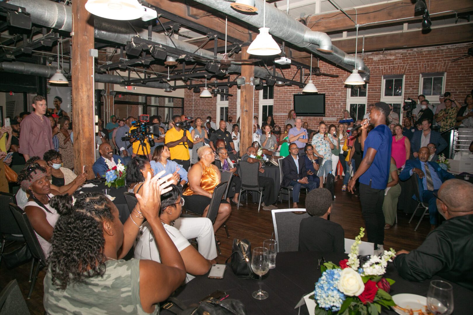 A crowd of people sitting at tables in an event.