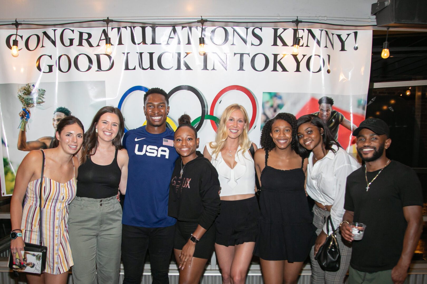 A group of people standing in front of a sign.