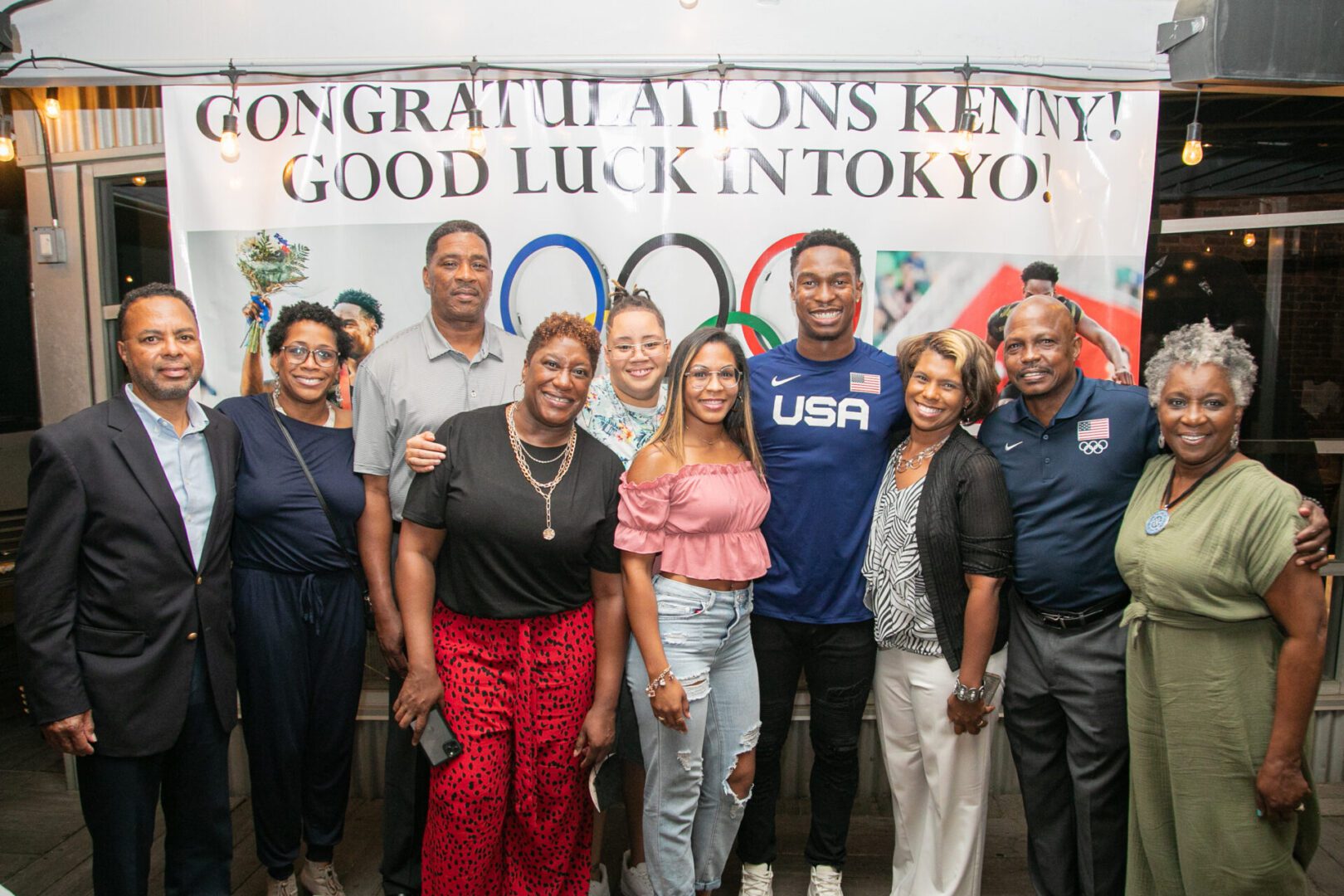 A group of people standing in front of a sign.