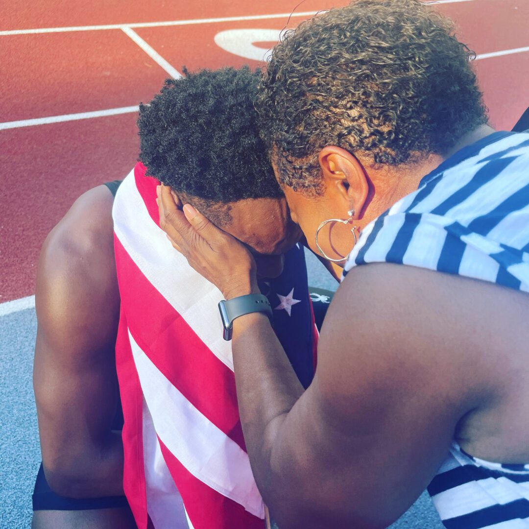 A man and woman hugging on the track.